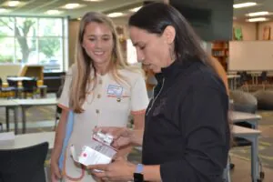 Margeaux Mueller showing Congresswoman Sharice Davids how to use Naloxone.